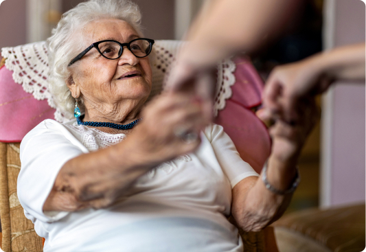 Mujer adulta siendo atendida para levantarse del sillón